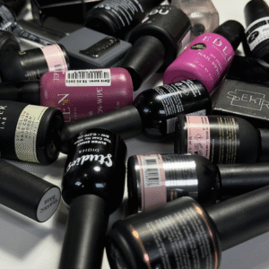 Surtido de botellas de esmaltes de uñas de gel, bases y top coats profesionales de diversas marcas, mostrando la amplia selección de productos de calidad utilizados por Katysol.